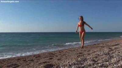 Beautiful honey in a crimson swimsuit got bare on the beach, while no one was seeing her on girlsporntube.one