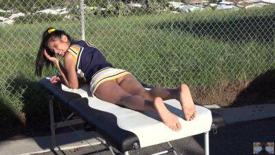 Cheerleader without panties sunbathing on the massage table on girlsporntube.one