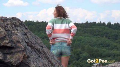 Pretty girl takes a piss while out walking in the country on girlsporntube.one